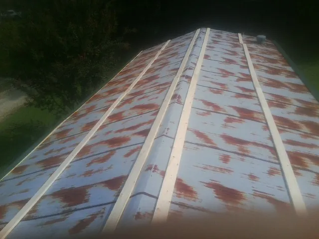 Rusted metal roof panels with new wood purlins before replacement — Storm Damage Roof Repair in Fowlerville by Roofing Brothers