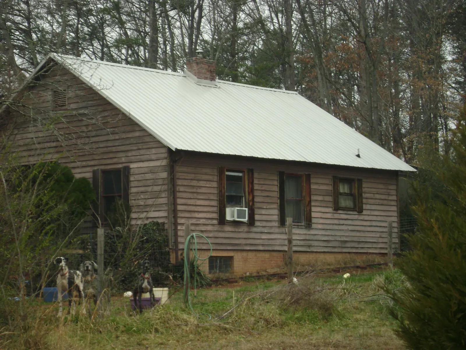 White metal roof on an old wood sided farmhouse, from a Metal Roof Installation job in Fowlerville